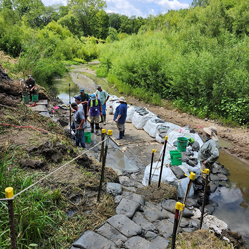 an excavation worksite in a small creek valley