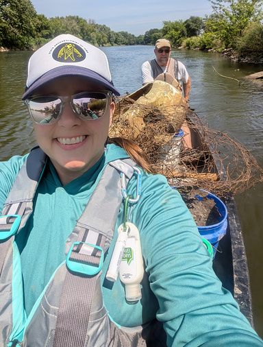 A women and a man in a canoe that is carrying a lot of metal trash