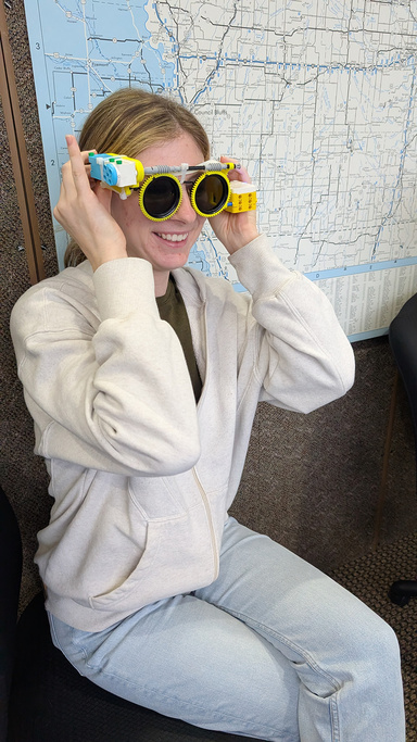 A woman wears sunglasses made from Legos and 3D printed parts
