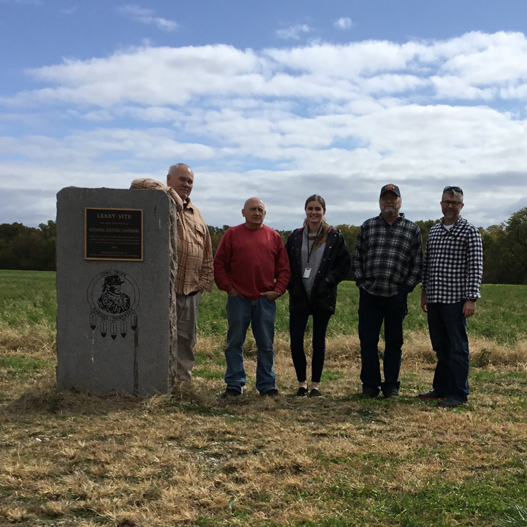 5 men standing by a monument