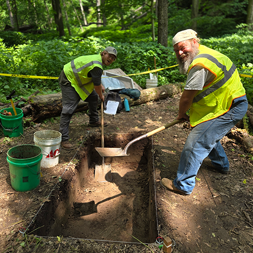 Two men excavating an archaeological unit