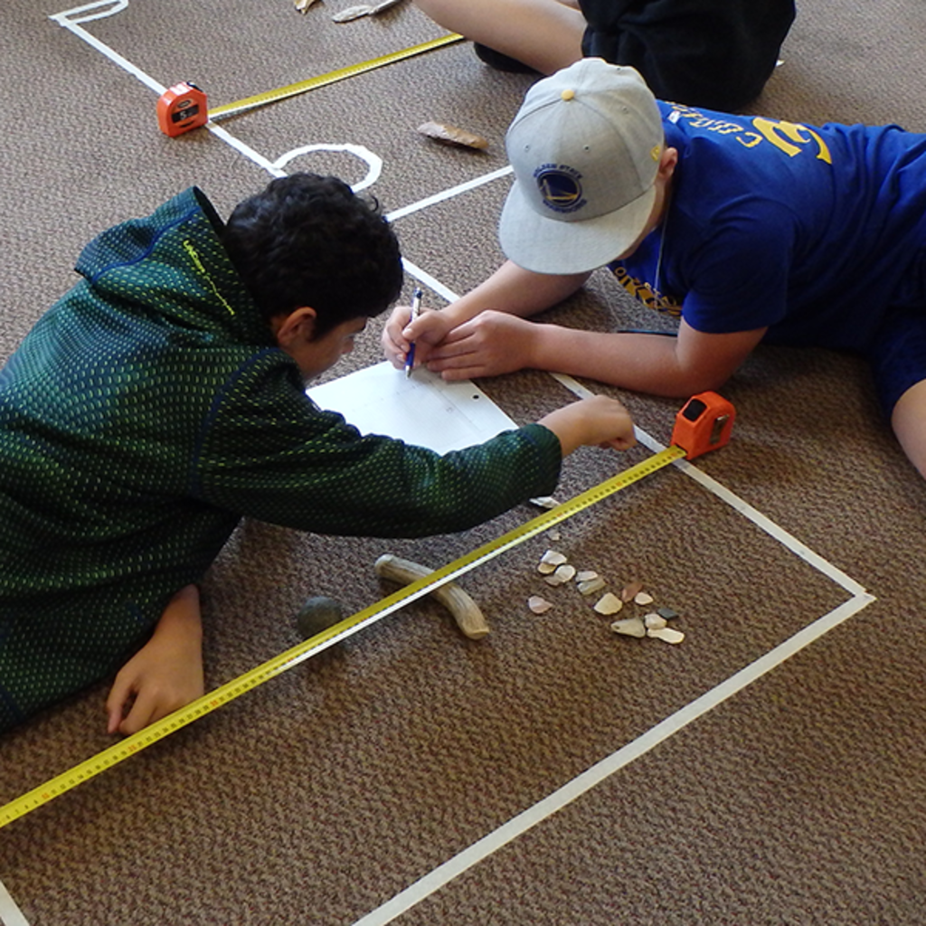 students mapping a simulated excavation unit on a carpet