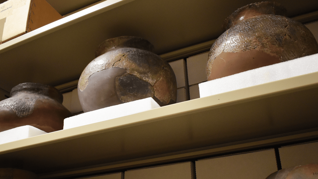 ancient pottery vessels displayed on a shelf