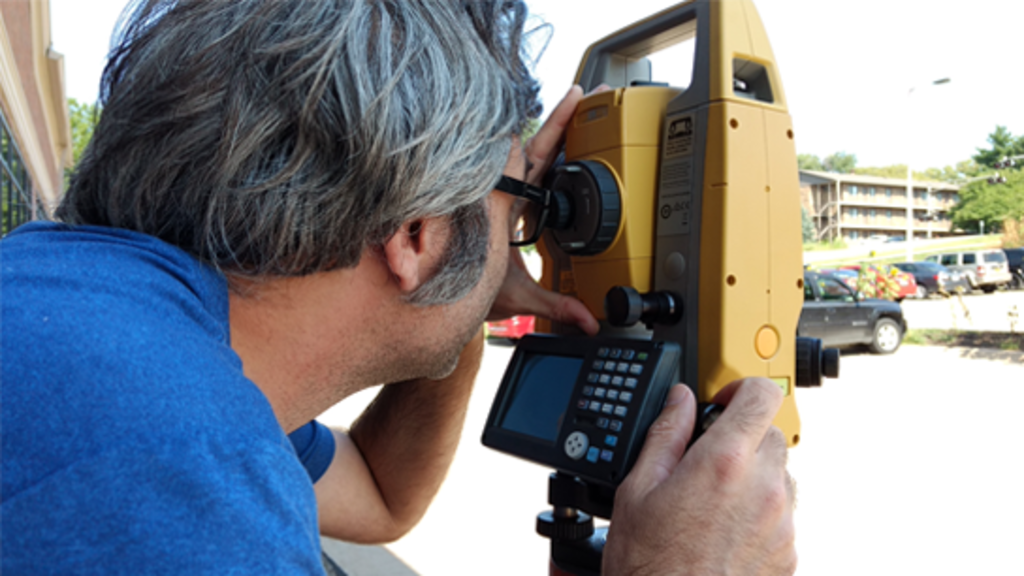 A man looks through a total station