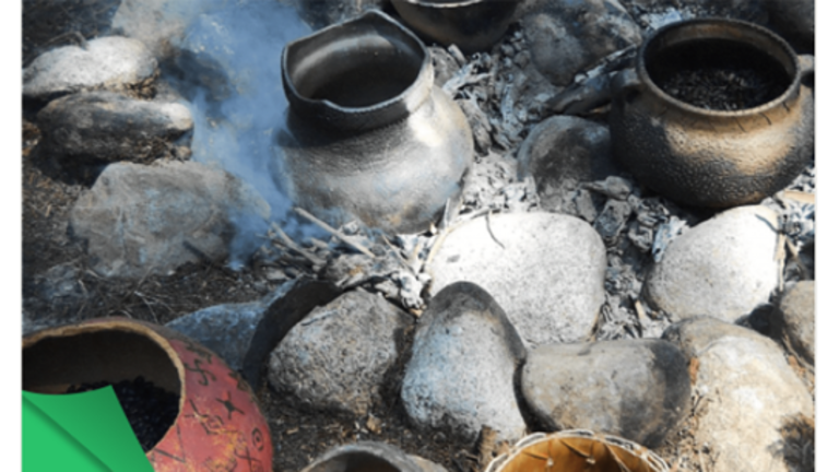 Replica ancient pots set into a smoldering hearth of boulders